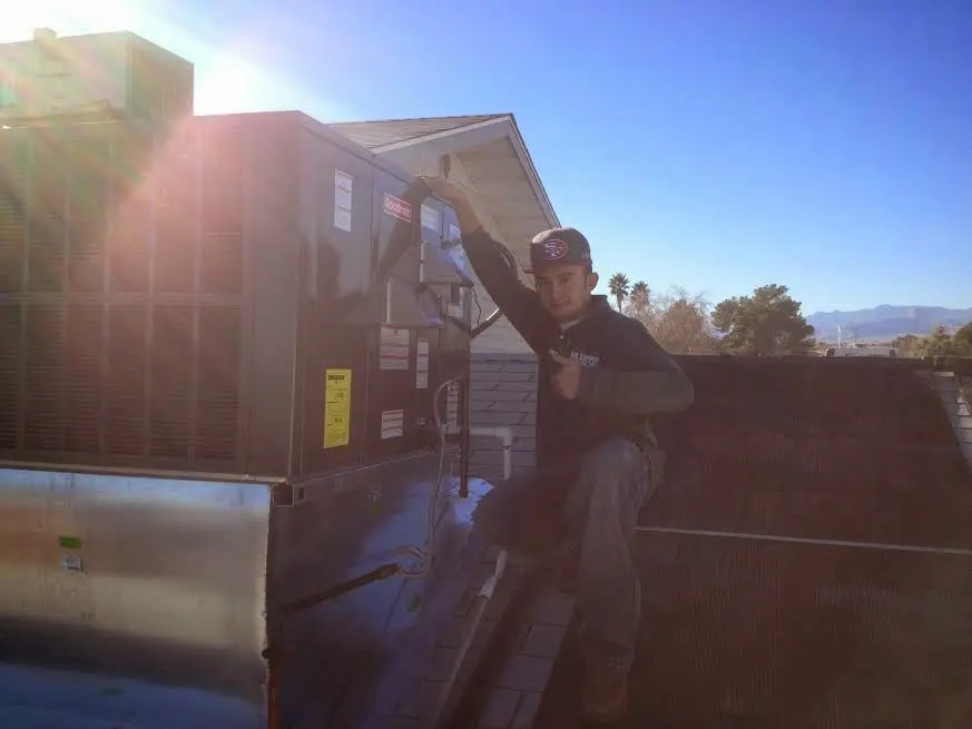 HVAC technician performing Boiler Repair on a rooftop unit in Walden